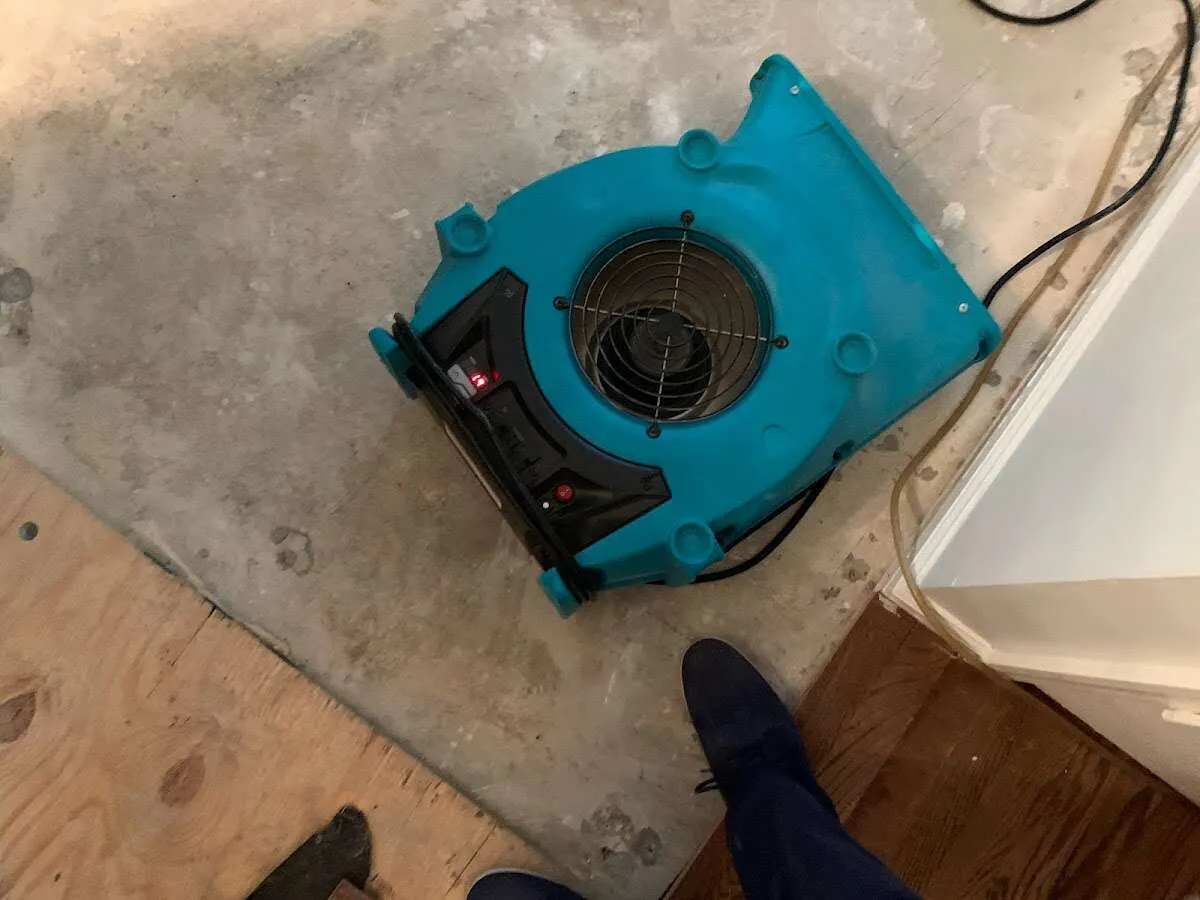 Air mover drying subfloor during Leak Detection & Repair in Tiverton